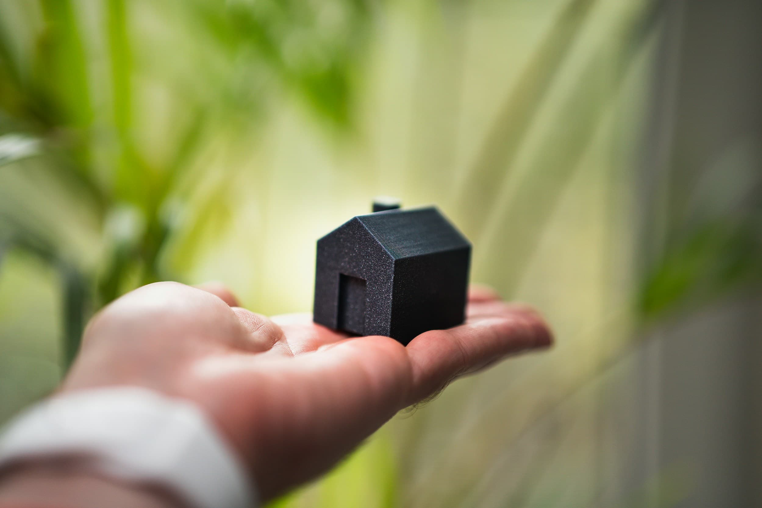 Hand holding a small house